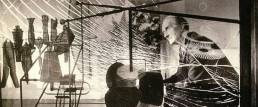 Duchamp fotografato da Mark Kauffman dietro al suo “Grande Vetro”